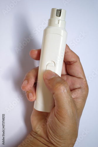 Woman's right hand holding dog electric nail file on white background, Electric manicure and pedicure, Accessories for manicure, Dog, Cat, Animal care in beauty salon concept, Close up shot