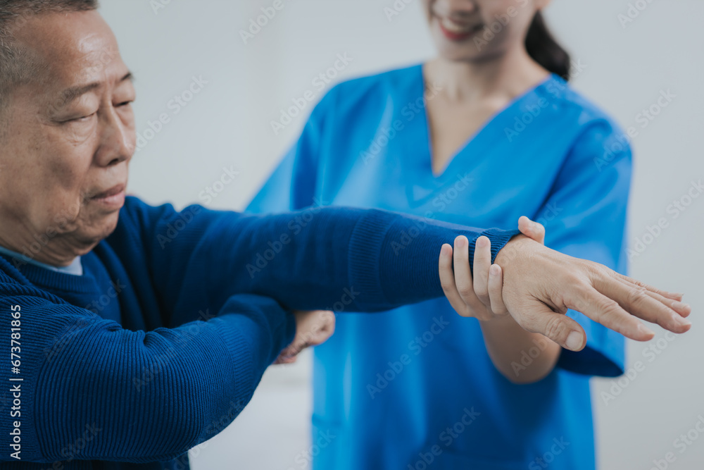 Fototapeta premium Asian female doctor or nurse exercising with elderly man at hospital