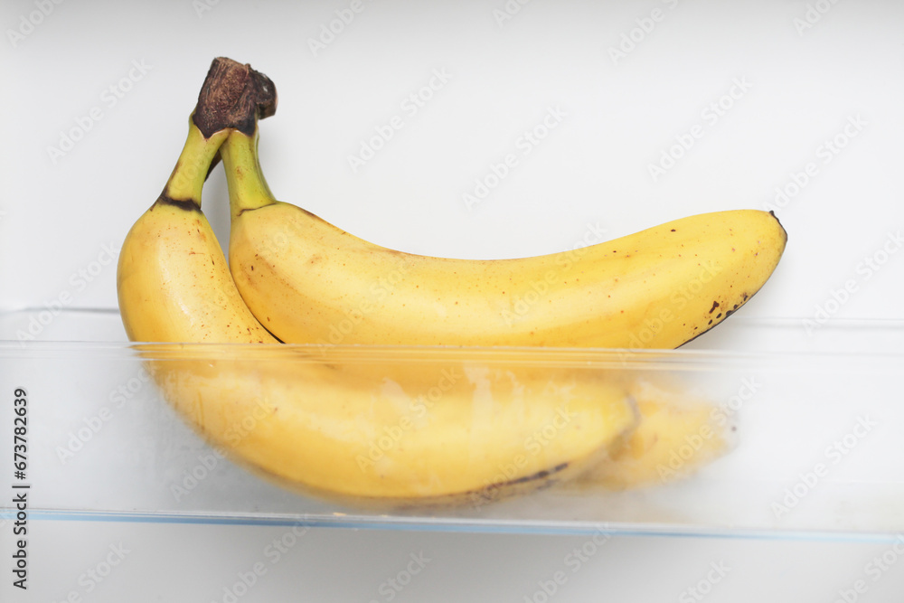 Bananas in fridge. Isolated on white fridge door. Yellow fruit with