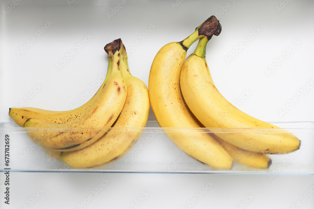 Bananas in fridge. Isolated on white fridge door. Yellow fruit with small brown spots. Ripe