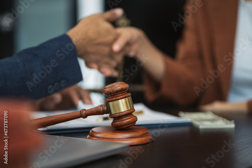 Lawyer shaking hands with client after discussing final contract agreement.