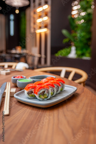 Sushi roll with salmon, shrimp, avocado and cream cheese on a plate