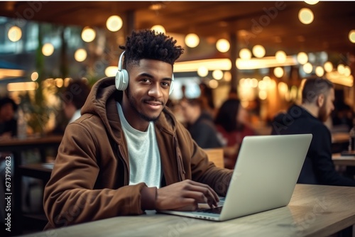 Handsome African American student doing his online homework in urban cafe. © visoot