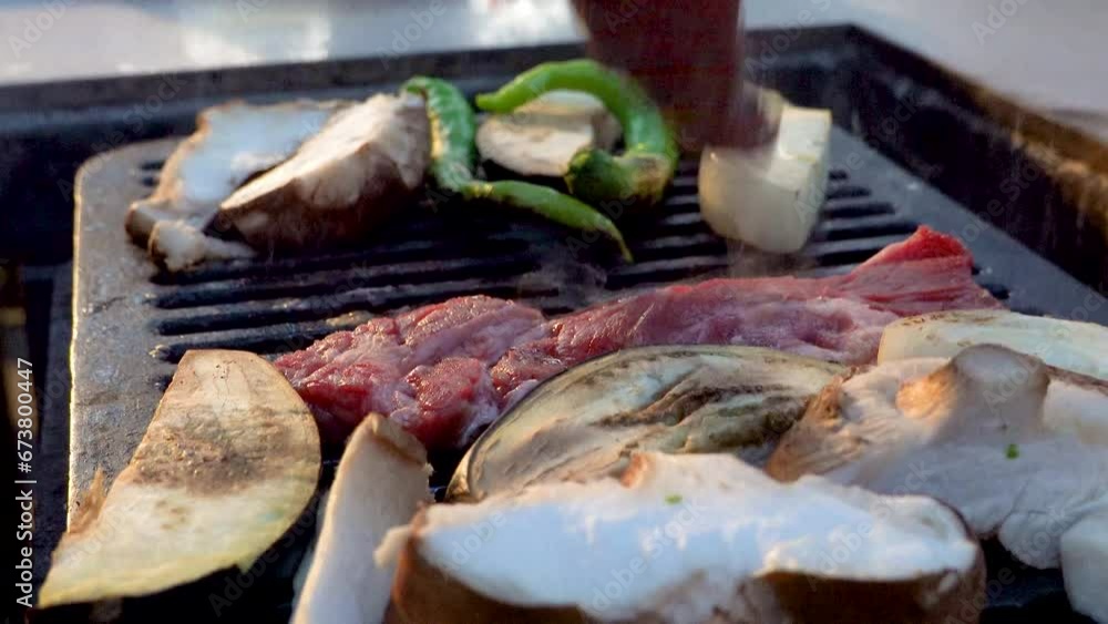 Grilling meat on an outdoor barbecue Grilling meat on an outdoor barbecue
