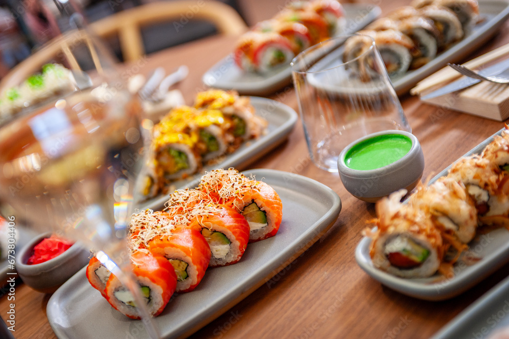 A set of sushi rolls on a table in a restaurant. A set of sushi rolls on a table in a restaurant.