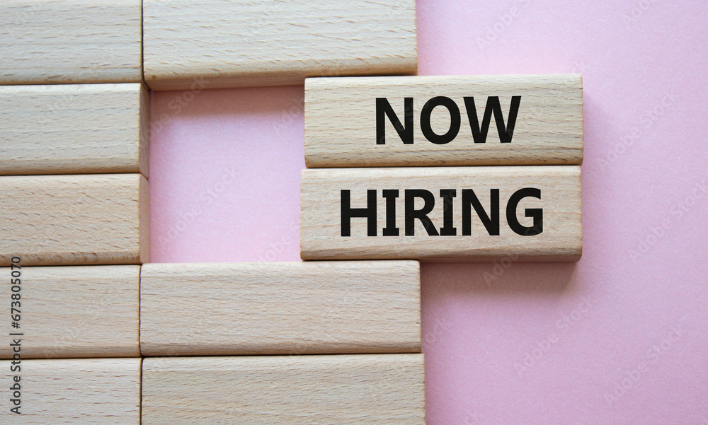 Now Hiring symbol. Concept word Now Hiring on wooden blocks. Beautiful pink background. Business and Now Hiring concept. Copy space Now Hiring symbol. Concept word Now Hiring on wooden blocks. Beautiful pink background. Business and Now Hiring concept. Copy space