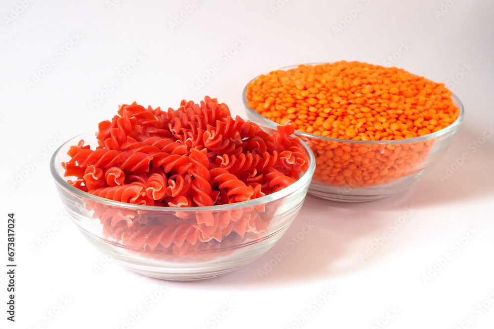 Red lentil fusilli pasta. Bowls with raw pasta and red lentils Red lentil fusilli pasta. Bowls with raw pasta and red lentils