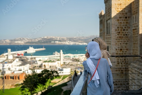 Two muslim girls looking over the port of Tanger in Morocco