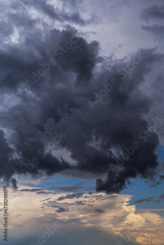 Epic Dramatic storm sky with dark grey cumulus rain clouds against blue sky background texture, thunderstorm