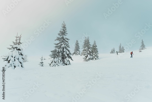 Group of people making their way up a snowy, wintery hill