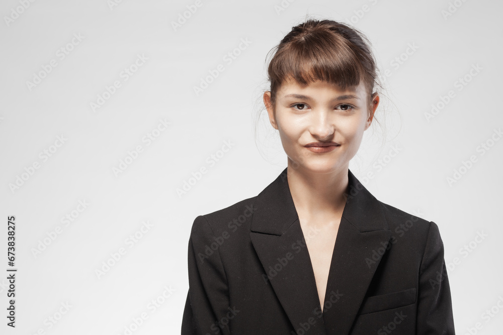 Cute girl in a suit against gray background. Happy young business woman posing. Cute girl in a suit against gray background. Happy young business woman posing.