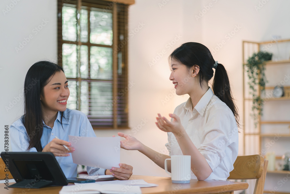 Two millennial Asian female office workers discussing and sharing business ideas together. Two millennial Asian female office workers discussing and sharing business ideas together.