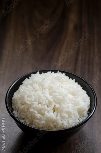Rice in cup on wooden table wth copy space