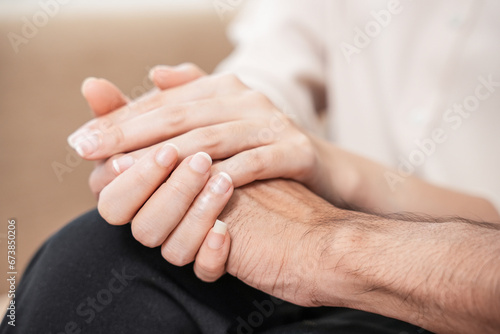 Close up of depression couple, patient consulting problem mental health with psychologist, psychiatrist at clinic together, husband encouraging by holding hand of wife, therapy health care.