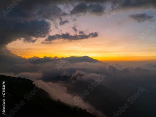 Sea of cloud over mountain peak at sunset