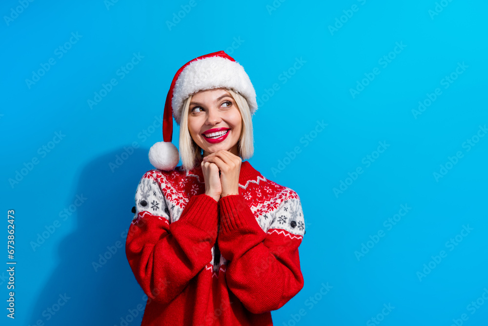 Obraz premium Portrait of gorgeous cheerful minded lady hands under chin look empty space christmastime atmosphere isolated on blue color background