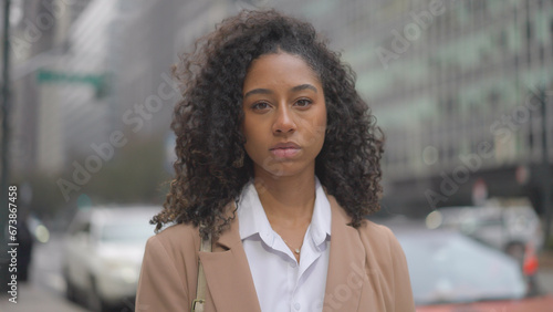 Young black business woman serious face portrait on city street
