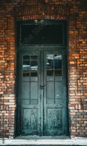 Old brick building in a train station with a black door in Anina City, Romania photo