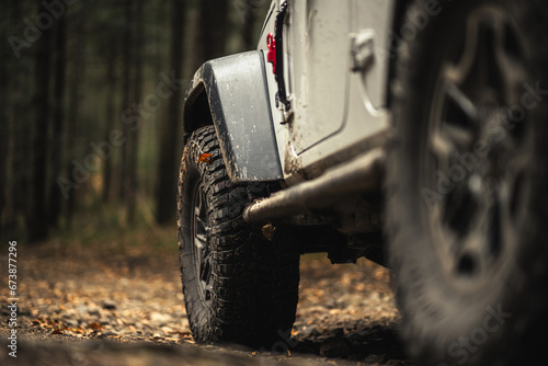Fotografie Four Wheel Drive Vehicle on the Muddy Forest Road