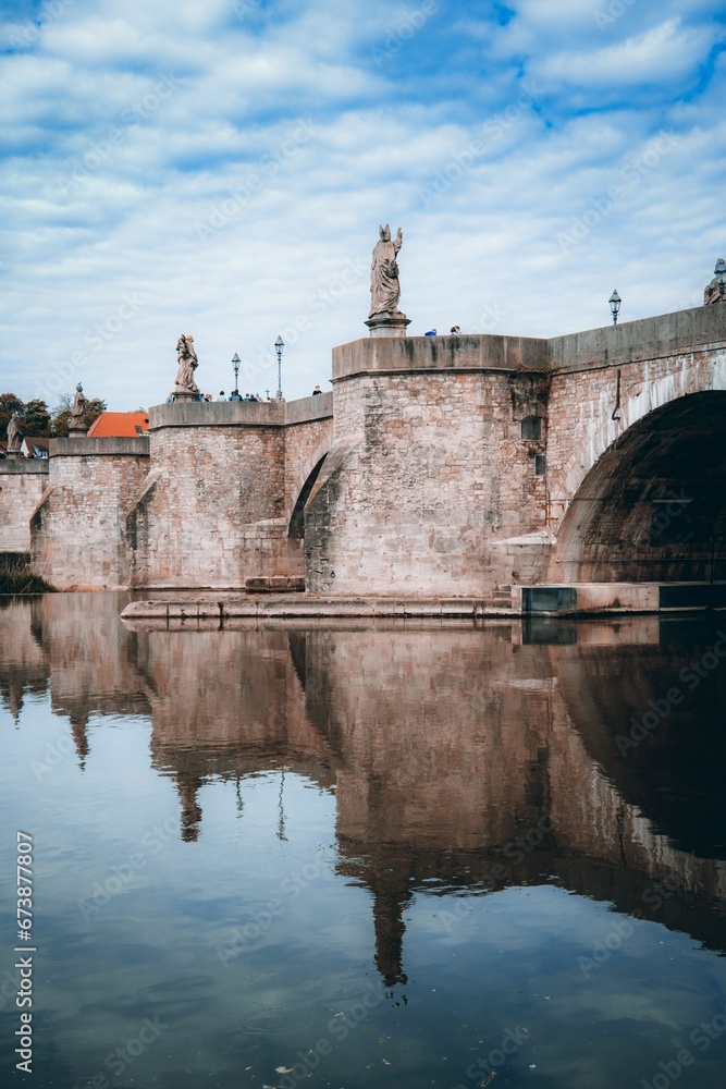 arched bridge with two statues of men standing at the peak of the arch, Wurzburg, Germany