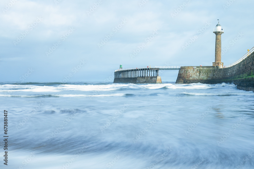 Whitby Pier with blue waves, pier and lighthouse