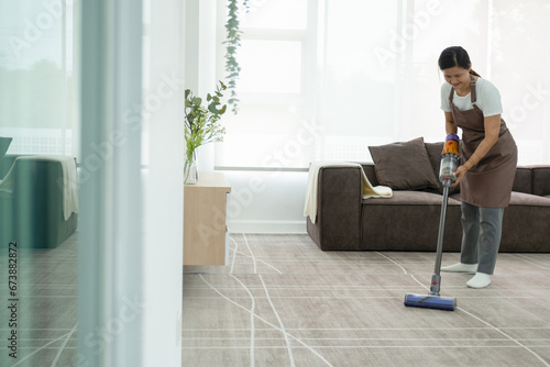 Woman cleaning house using vacuum cleaner. © MIND AND I
