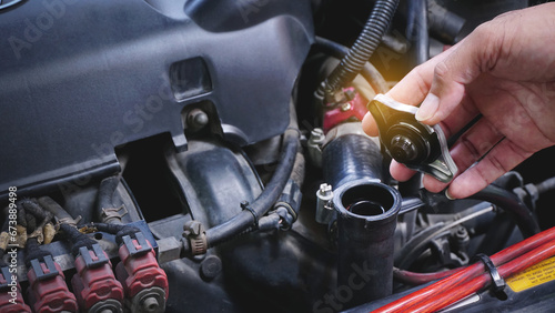 Hands man auto mechanic checking coolant water level in radiator car engine on car engine background for maintenance or repair service concept.