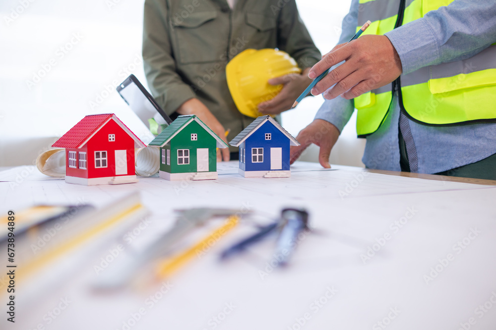 Architects and construction engineers meet to discuss blueprints of building structures in order to calculate the completion of the construction project. Real estate construction business concept. Architects and construction engineers meet to discuss blueprints of building structures in order to calculate the completion of the construction project. Real estate construction business concept.
