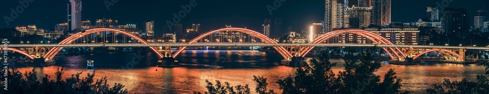 Panoramic view of Wenhui Bridge with its bright night illumination. Liuzhou, China.