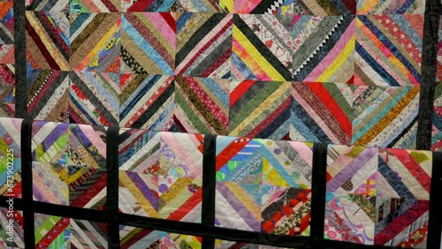 This video shows a close up view of a detailed and colorful hand made quilt.