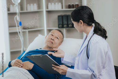 Photography Beautiful Asian female doctor in white top talking with senior patient at bedsid
