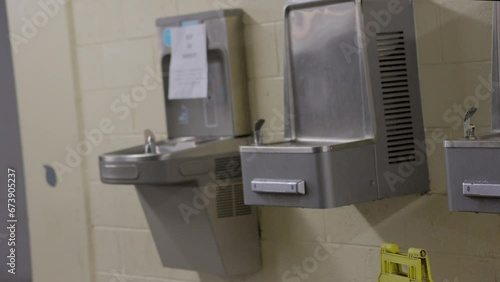 This panning video shows a row of old water fountains.