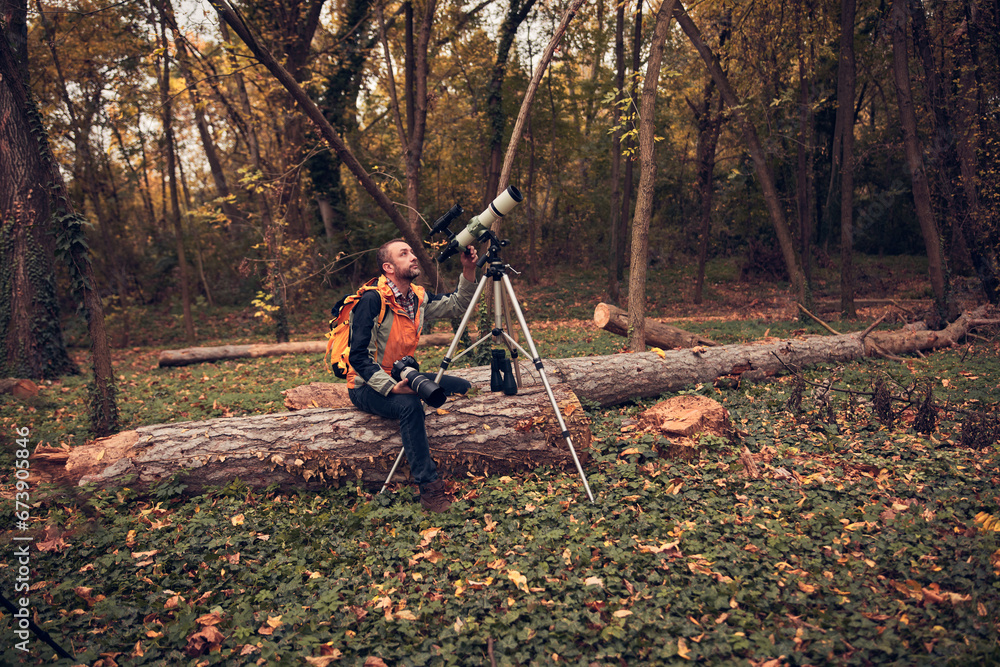 Man using telescope for bird and animal watching in nature. Man using telescope for bird and animal watching in nature.