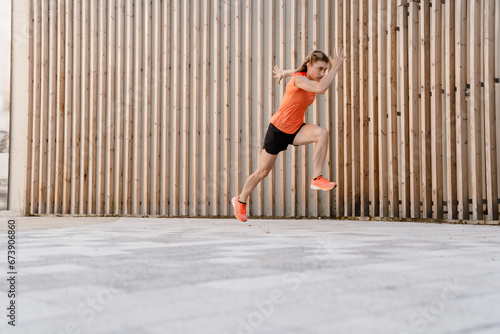 Athletic fitness woman sprinting outdoors