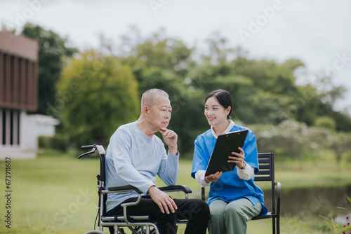 Happy young nurse talks to an elderly man with a disability © Witoon