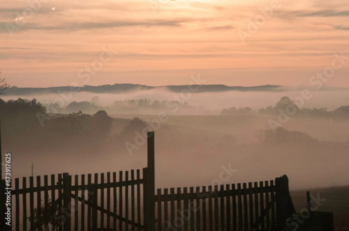 Foggy morning in the brazil countryside, with a wooden fence