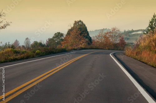 View on the road in the countryside during autumn season at sunrise. © Miriana