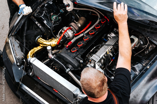 mechanics check the car engine before driving. under the hood. extreme sport. racing car engine problems. 