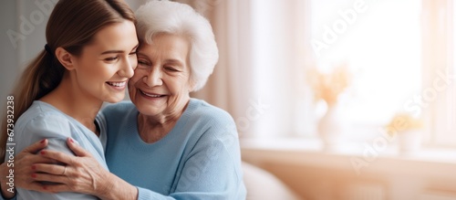 Nurse hugging elderly patients during visit at home photo