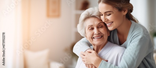 Nurse hugging elderly patients during visit at home