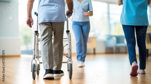 Physical therapist helpful patients to walking with walker © ETAJOE