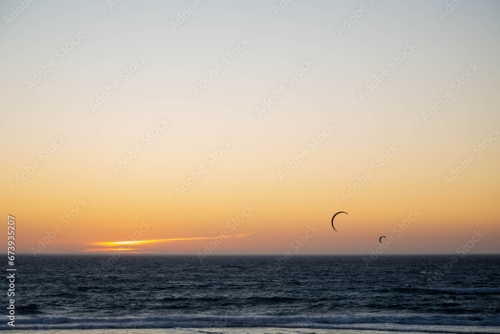 Two parachutes for kitesurfing against the background of the sunset sky and the ocean. Sea landscape with sunset.