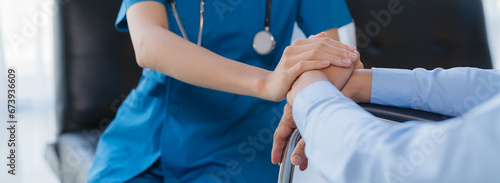 Cropped shot of a female nurse hold her senior patient's hand. Giving Support. Doctor helping old patient with Alzheimer's disease. Female carer holding hands of senior man photo