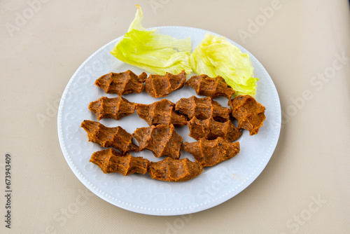 Cig kofte (raw meatball) with lettuce, tomato, pickle and lemon, hot Chee kofta. Turkish local raw food concept.Table scene of assorted take out or delivery foods. Doritoslu duble cig kofte durum. photo