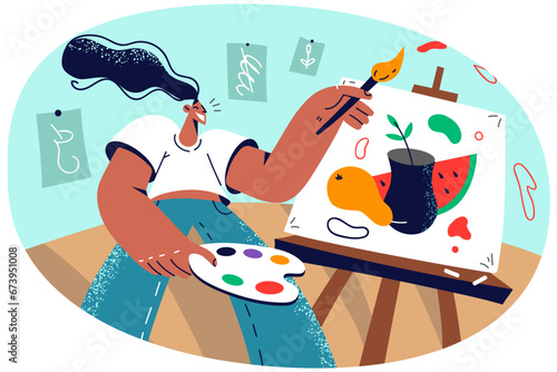 Smiling girl painting on easel