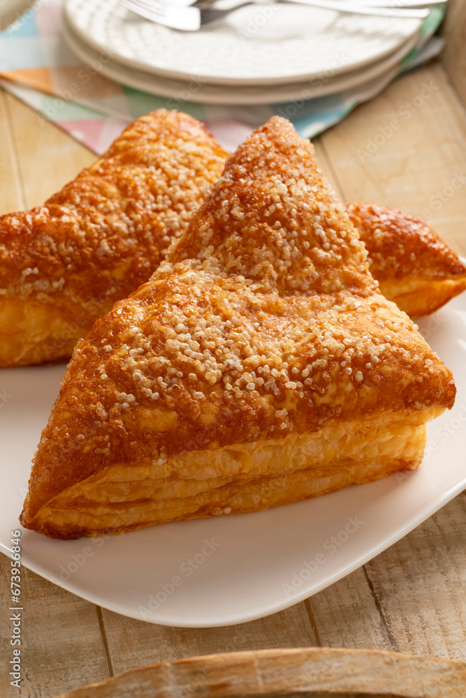 Plate with baked sweet puff apple triangles pastry as a snack close up Plate with baked sweet puff apple triangles pastry as a snack close up