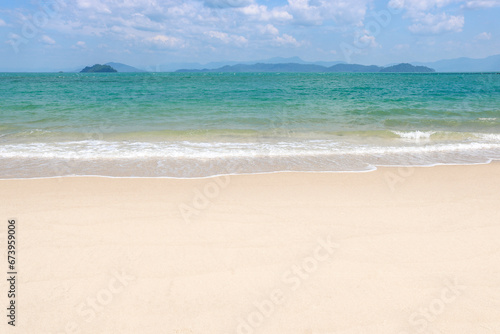 White tropical beach with an island in the background. Time for vacation and relaxation, copy space.