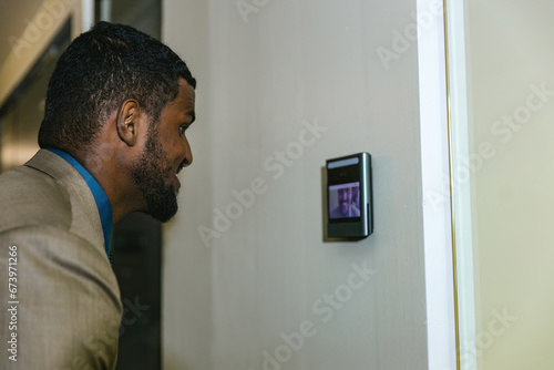 Man using face scanner to unlock door in office building. Access control facial recognition system. Biometric admittance control device for security system. Biometric admittance control device