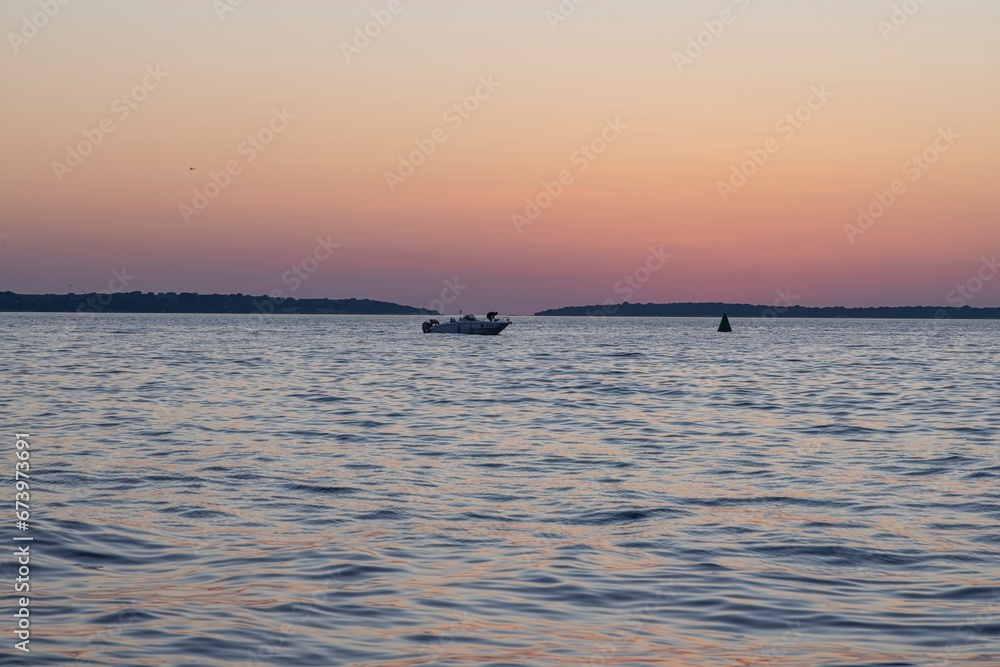 Picture of the sunset taken from the beach of the Croatian coastal town of Fazana with a motorboat Picture of the sunset taken from the beach of the Croatian coastal town of Fazana with a motorboat