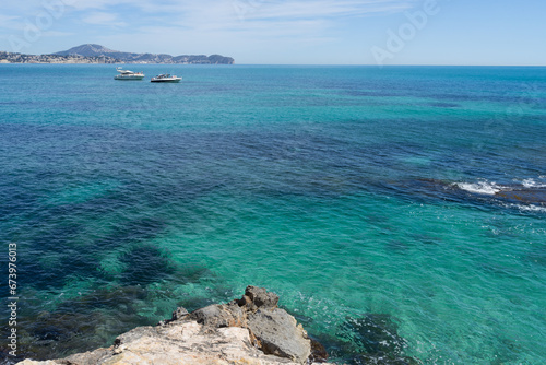 turquoise sea water and boats on the Mediterranean coast in Spain tourism and summer holidays by the sea